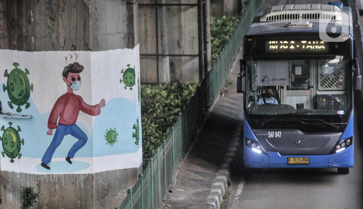 Bus transjakarta melintasi mural bertema protokol kesehatan Covid-19 yang menghiasi tiang pancang jalan tol di Jalan Ahmad Yani, Jakarta, Minggu (13/12/2020). (merdeka.com/Iqbal S. Nugroho)