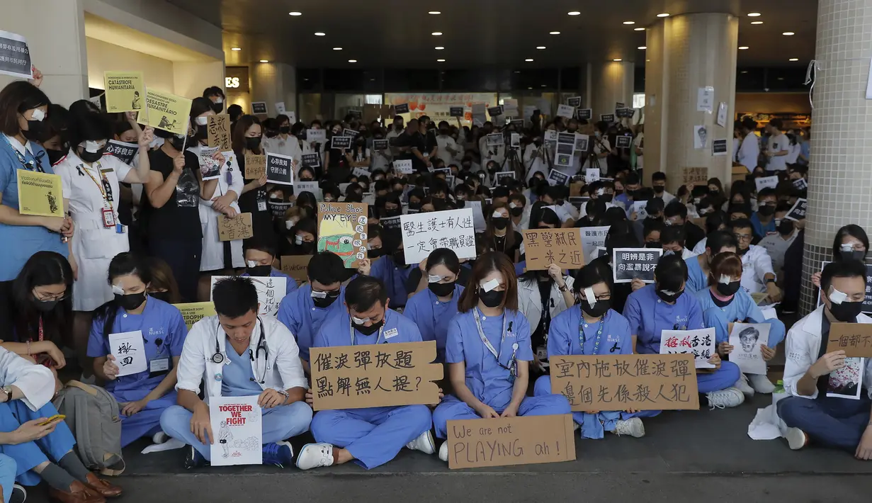 Perawat dan staf medis saat unjuk rasa rasa di sebuah rumah sakit di Hong Kong (13/8/2019). Para pemrotes berunjuk rasa menentang kebrutalan polisi pada aksi-aksi demonstrasi akhir pekan. (AP Photo/Kin Cheung)