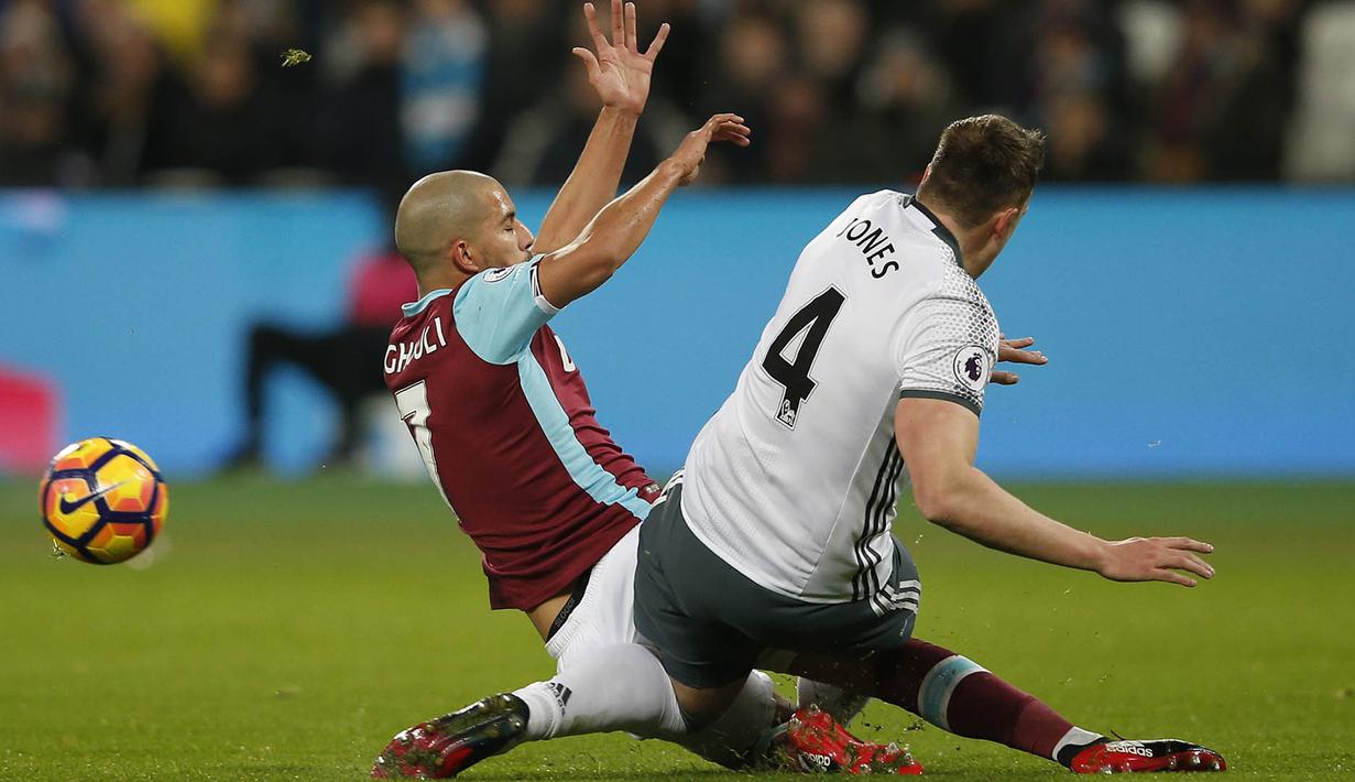 Gelandang West Ham, Sofiane Feghouli, melakukan tekel keras terhadap bek Manchester United, Phil Jones. Akibat tekel keras yang terjadi pada menit ke-15 tersebut, wasit memberikan Feghouli hukuman kartu merah. (AFP/Adrian Dennis)