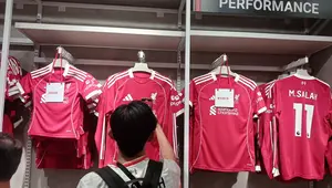 Seorang pengunjung memeriksa dari dekat jersey kandang terbaru Liverpool di Liverpool FC Store Indonesia di Pondok Indah Mal 2, Jakarta, Jumat (1/8/2025). (Bola.com/Hery Kurniawan).