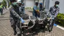 Petugas membawa puing AirAsia QZ8501 berupa bangku yang sudah rusak parah, Bandara Juanda, Rabu (7/1/2015). (AFP Photo/Juni Kriswanto)