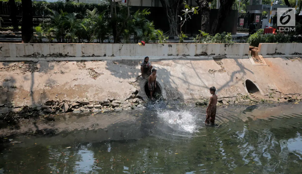 Sejumlah anak-anak berenang di kali menteng, Jakarta, Selasa (20/8/2019). Kurangnya lahan bermain membuat mereka terpaksa memanfaatkan kali menteng yang kotor sebagai tempat bermain. (Liputan6.com/Faizal Fanani)