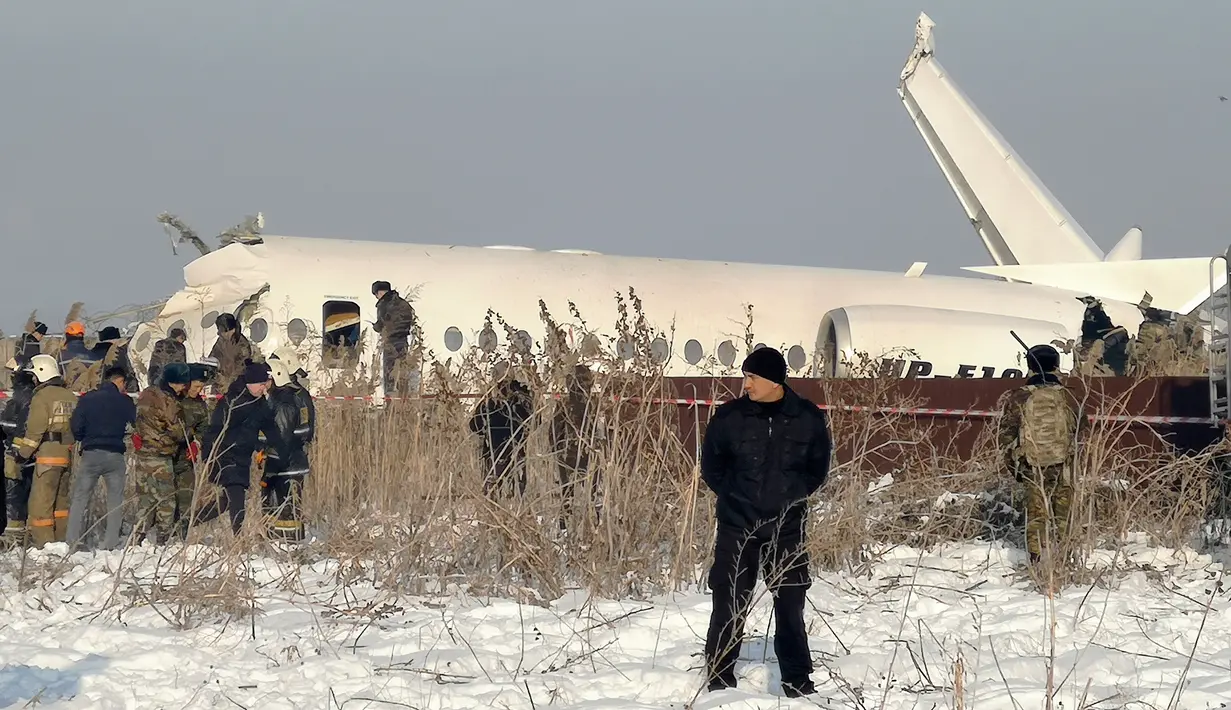 Polisi berjaga saat petugas penyelamat mengevakuasi korban jatuhnya pesawat maskapai Bek Air di dekat Bandara Almaty, Kazakhstan, Jumat (27/12/2019). Pesawat yang mengangkut 100 penumpang termasuk lima awak  itu jatuh sesaat setelah lepas landas. (AP Photo/Vladimir Tretyakov)