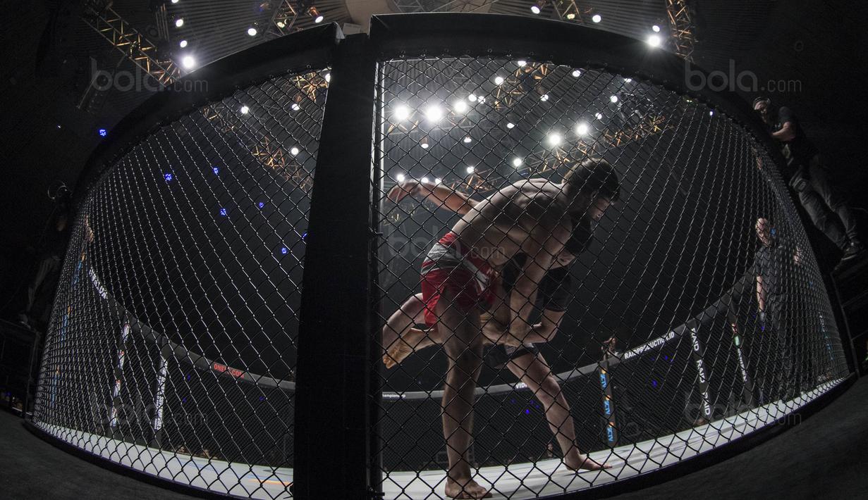 Petarung Jepang, Shinya Aoki, berusaha menjatuhkan petarung Rusia, Marat Gafurov, saat laga One Championship di JCC Senayan, Jakarta, Sabtu (20/1/2018). Aoki berhasil mengalahkan Gafurov. (Bola.com/Vitalis Yogi Trisna)