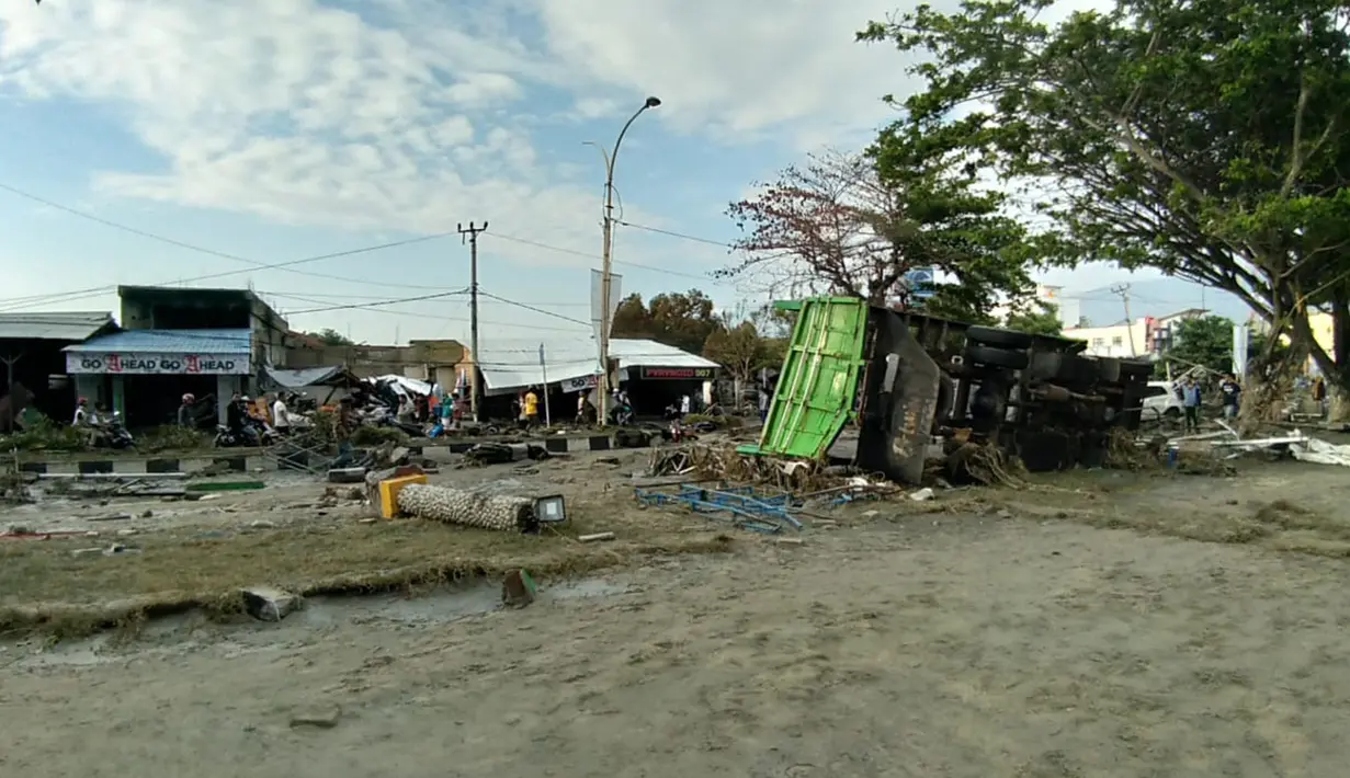 Sejumlah warga memeriksa kerusakan akibat gempa dan tsunami di Palu, Sulawesi Tengah , Sabtu (29/9). Gelombang tsunami setinggi 1,5 meter yang menerjang Palu terjadi setelah gempa bumi mengguncang Palu dan Donggala. (AFP /OLA GONDRONK)