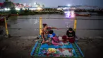 Orang-orang berkumpul di dermaga saat terjadi pemadaman listrik di Yangon, Myanmar pada Jumat (26/4/2024). (Sai Aung MAIN / AFP)