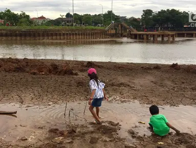 Anak-anak bermain di sekitar kawasan Danau Setu Babakan yang mengering di Jakarta, Jumat (5/1). Mereka bermain sambil mengisi waktu libur sekolah. (Liputan6.com/Immnanuel Antonius)