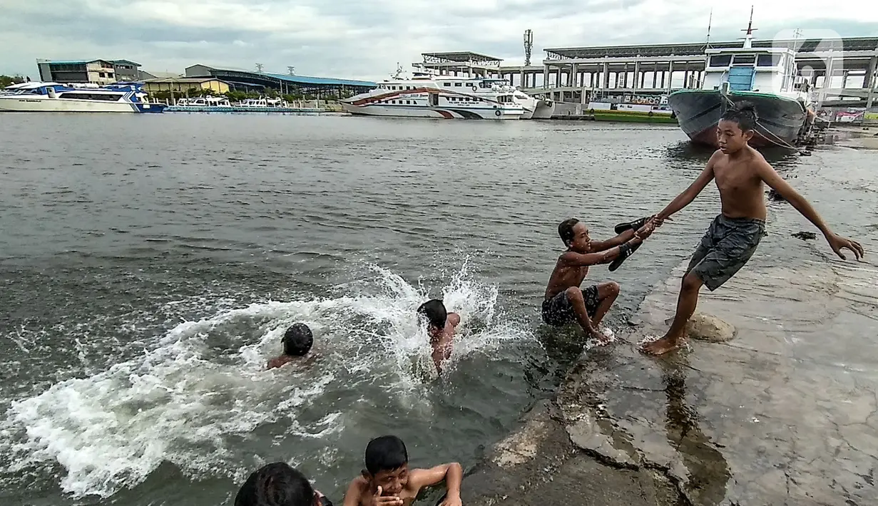 Anak-anak berenang di dermaga saat banjir rob merendam Pelabuhan Kali Adem, Muara Angke, Jakarta, Kamis (22/10/2020). Banjir rob yang merendam kawasan Pelabuhan Kali Adem sejak lima hari lalu dimanfaatkan oleh anak-anak setempat untuk berenang di sekitar dermaga. (merdeka.com/Iqbal S. Nugroho)