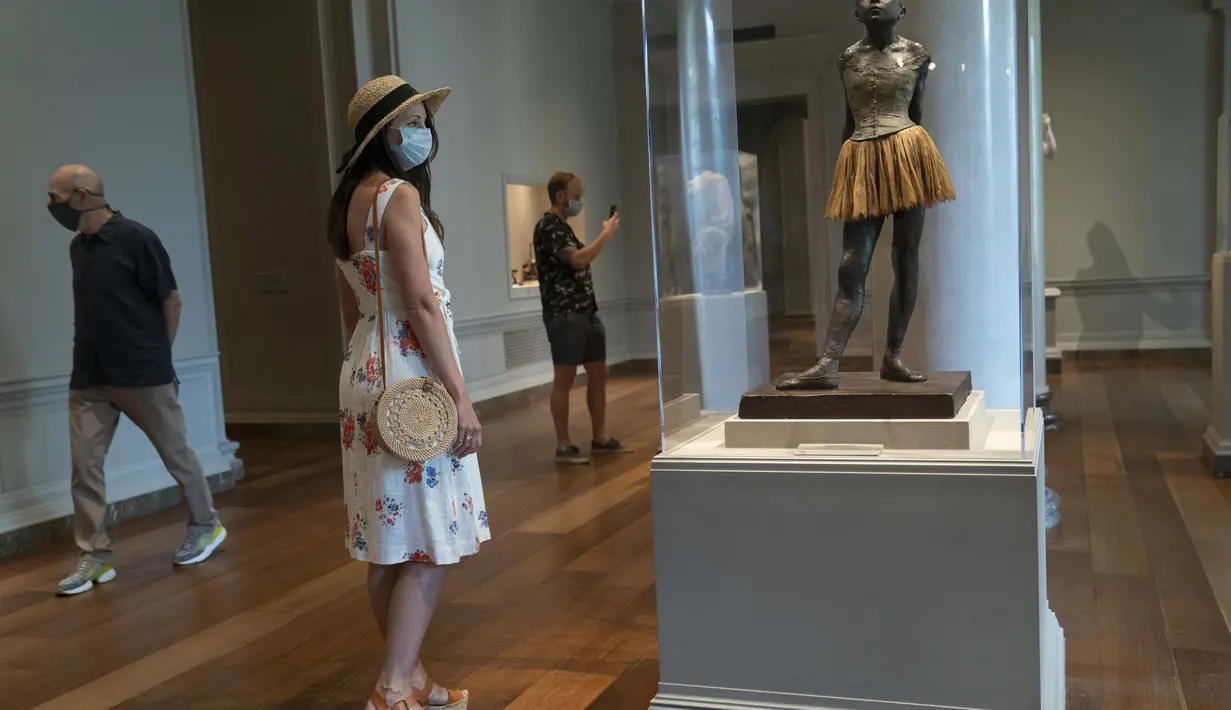 Pengunjung yang mengenakan masker melihat-lihat karya seni yang dipamerkan di Gedung Barat Galeri Seni Nasional di Washington DC, AS (20/7/2020). Sebagian galeri tersebut dibuka kembali untuk umum pada Senin (20/7) setelah ditutup selama berbulan-bulan akibat pandemi COVID-19. (Xinhua/Liu Jie)