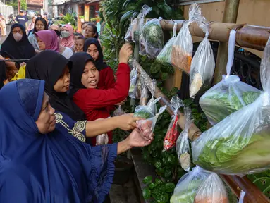 Warga memilih sayur dan pakaian bekas saat bazar sayuran, bahan makanan dan pakaian layak pakai gratis di Jalan Jati Padang VI, Pasar Minggu, Jakarta, Jumat (29/3/2024). (merdeka.com/Arie Basuki)