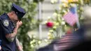 Petugas New York City Police Department (NYPD) menangis saat menghadiri upacara peringatan 16 tahun korban serangan 11 September di Museum dan Memorial Nasional 9/11, New York, Amerika Serikat, Senin (11/9). (Drew Angerer/Getty Images/AFP)