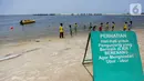 Papan imbauan waspada ubur-ubur terpasang di Pantai Lagoon, Ancol Taman Impian, Jakarta, Rabu (9/10/2019). Kawanan ubur-ubur mulai terlihat di Pantai Lagoon Ancol sejak 6 Oktober lalu. (Liputan6.com/Faizal Fanani)