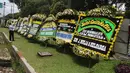 Warga mengambil gambar karangan bunga ucapan duka cita untuk Probosutedjo yang memenuhi Jalan Diponegoro, Jakarta, Senin (26/3). Probosutedjo meninggal dunia pada usia 87 tahun. (Liputan6.com/Arya Manggala)