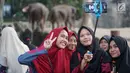 Wisatawan berswafoto saat berlibur di Taman Margasatwa Ragunan (TMR), Jakarta, Kamis (6/6/2019). Setidaknya sebanyak 49.394 warga Ibu Kota dan sekitarnya mengisi libur Lebaran bersama keluarga dengan mengunjungi destinasi liburan murah meriah tersebut. (Liputan6.com/Immanuel Antonius)