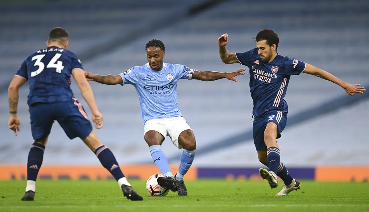 Pemain Manchester City Raheem Sterling (tengah) berebut bola dengan pemain Arsenal Granit Xhaka (kiri) dan Dani Ceballos pada pertandingan Liga Premier Inggris di Etihad Stadium, Manchester, Inggris, Sabtu (17/10/2020). Manchester City menang 1-0. (Michael Regan/Pool via AP)