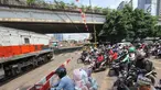 Pengendara menanti di pintu perlintasan kereta sebidang di Jalan KH Mas Mansyur, Jakarta, Senin (30/10). Perlintasan sebidang ini rencananya segera ditutup karena dianggap menjadi salah satu titik kemacetan di Jakarta Pusat. (Liputan6.com/Angga Yuniar)