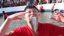 Peserta memegang trout di mulut setelah menangkapnya selama kontes menangkap ikan di Hwacheon, Korea Selatan, Sabtu (5/1). Kontes ini merupakan bagian dari festival es tahunan yang menarik lebih dari satu juta pengunjung setiap tahun. (AP/Ahn Young-joon)