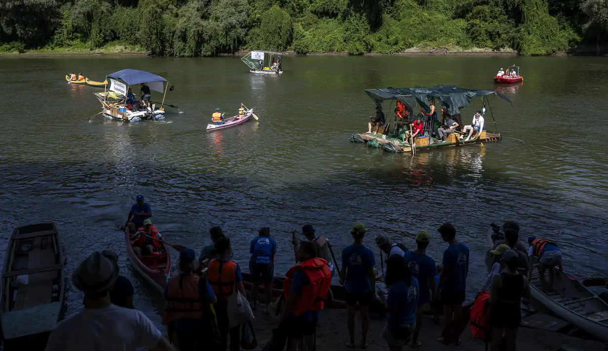 Para pengunjung sungai yang mengenakan jaket pelampung dari segala usia, yang menumpuk di dalam lusinan sampan untuk menjelajahi sungai terbesar kedua di Hongaria mencari sampah yang mengalir ke hilir. (AP Photo/Denes Erdos)