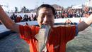 Seorang peserta berpose dengan ikan dengan saat acara Festival Es di sungai Hwacheon yang membeku di Korea Selatan, Sabtu (14/1). (AP Photo/Ahn Young-joon)