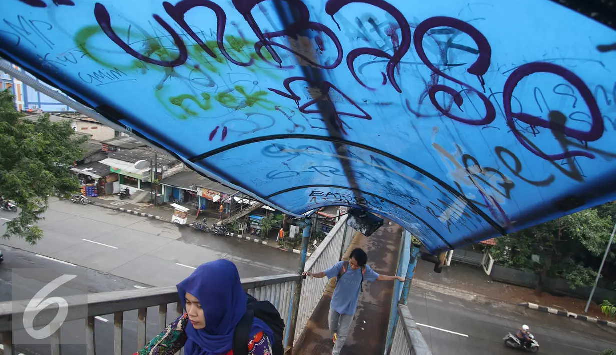  Pejalan kaki melintasi jembatan penyeberangan orang (JPO) yang tidak terawat di kawasan Universitas Indonesia, Depok, Jawa Barat, Selasa (11/10). (Liputan6.com/Immanuel Antonius)