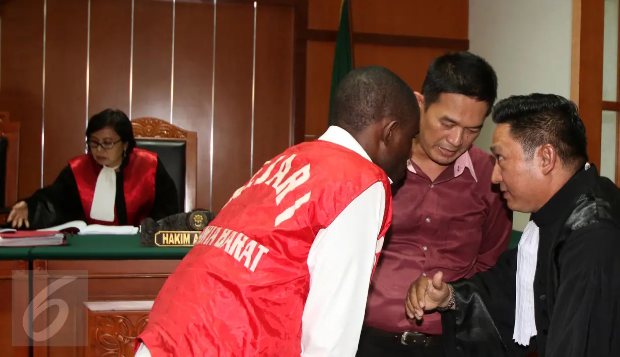 Warga negara Nigeria, Arinze Petrus Eneh (kiri) saat berkonsultasi dengan kuasa hukumnya saat sidang di PN Jakarta Barat, Jakarta, (18/5). Arinze Petrus sebelumnya dituntut hukuman mati oleh Jaksa Penuntut Umum. (Liputan6.com/Helmi Afandi)