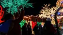 Seorang wisatawan memotret sebuah rumah yang dihiasi lampu Natal di lingkungan Dyker Heights, Brooklyn, New York, Amerika Serikat, 21 Desember 2022. Dyker Heights adalah salah satu kawasan Kota New York yang paling menakjubkan dengan dekorasi meriah selama musim libur akhir tahun. (AP Photo/Julia Nikhinson)