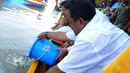 Rano Karno bersama pejabat pemda lainnya menebar anak ikan di bibir Sungai Cisadane, Kota Tangerang, Senin (2/6/14). (Liputan6.com/Faisal R Syam)