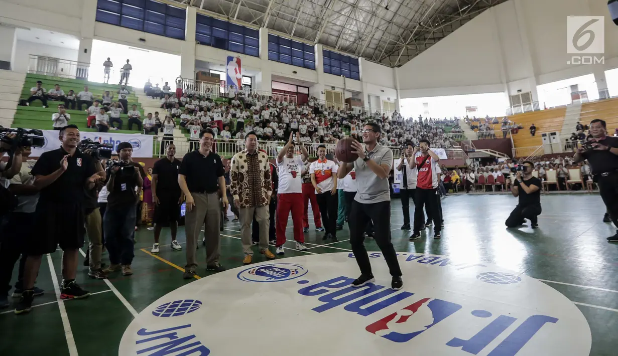 Wakil Gubernur DKI Jakarta Sandiaga Salahudin Uno saat melakukan tembakan three point usai membuka pelatihan pendidikan Basket di Gor Ciracas, Jakarta, Rabu (24/1). Pendidikan ini diberikan oleh  Akademi pelatih Jr. NBA. (Liputan6.com/Faizal Fanani)