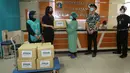 Senior VP Head of Institutional Banking Group 4 PT Bank DBS Indonesia, Angela Thenaria disaksikan Community Manager Surplus Indonesia, Alya Fatina menyerahkan donasi berupa sembako dan makanan ringan berlebih kepada nakes, petugas keamanan dan pengemudi ambulans. (Liputan6.com/Fery Pradolo)