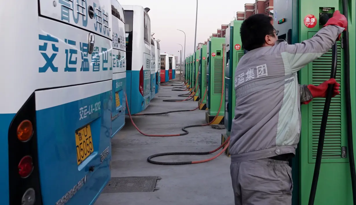 Seorang staf mengisi daya bus listrik di Wilayah Laixi, Provinsi Shandong, China, 14 Januari 2020. Untuk mengurangi emisi karbon dan melestarikan lingkungan, Wilayah Laixi telah mengonversi seluruh bus umum yang dimilikinya menjadi 116 bus listrik di area perkotaan sejauh ini. (Xinhua/Ding Hongfa)