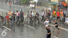 Hujan mengguyur kawasan Bundaran HI saat kegiatan Car Free Day di Jakarta, Minggu (24/1/2016). Sejumlah pengunjung tetap melaksanakan olahraga di bawah guyuran hujan. (Liputan6.com/Helmi Affandi)