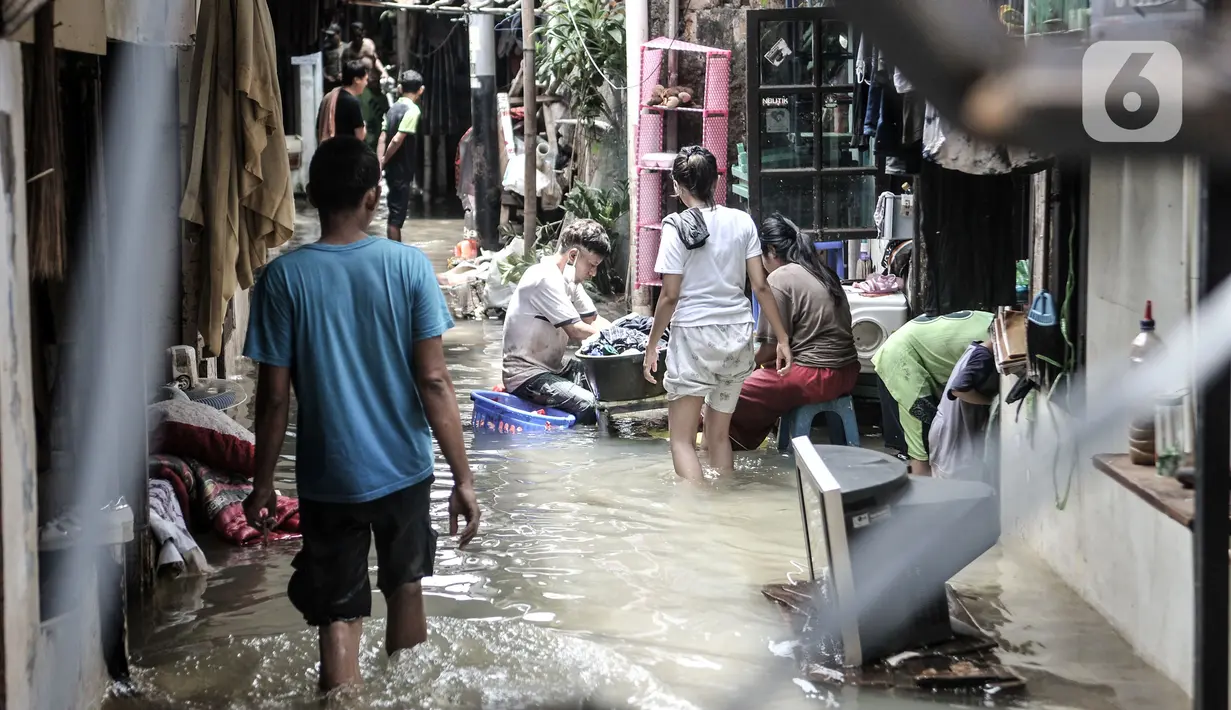 Warga beraktivitas di tengah banjir yang merendam permukiman warga di Kemang Timur XI, Jakarta, Minggu (21/2/2021). Warga berharap pemerintah segera memperbaiki longsor agar banjir tidak berkepanjangan. (merdeka.com/Iqbal S. Nugroho)
