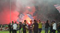 Aremania menyalakan flare merayakan kemenangan Arema Cronus atas Persela Lamongan. (Bola.com/Fahrizal Arnas)