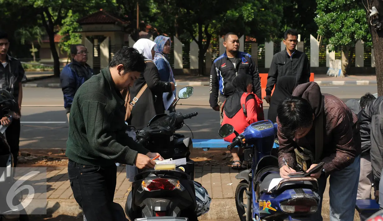 Warga mengisi formulir di sekitar Gerai Samsat Keliling di Jalan Kalibata Raya, Jakarta, Senin (11/7). Pasca libur lebaran 2016, gerai Samsat Keliling kembali beroperasi melayani pembayaran pajak kendaraan bermotor. (Liputan6.com/Helmi Fithriansyah)