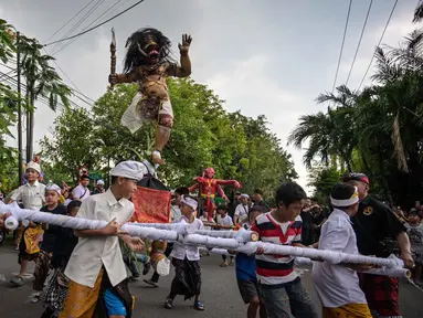 Umat Hindu membawa Ogoh-ogoh, patung yang melambangkan roh jahat, selama pawai menjelang Nyepi di Surabaya pada Rabu 18 Maret 2026. Menyambut datangnya Hari Raya Nyepi, umat Hindu di kota Surabaya, Jawa Timur, menggelar pawai Ogoh-ogoh. (JUNI KRISWANTO/AFP)
