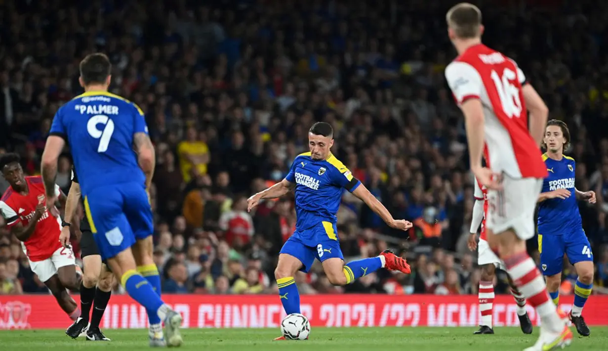 Pemain AFC Wimbledon Anthony Hartigan (tengah) mengontrol bola saat melawan Arsenal pada pertandingan Piala Liga Inggris di Emirates Stadium, London, Inggris, 22 September 2021. Arsenal menang 3-0. (JUSTIN TALLIS/AFP)
