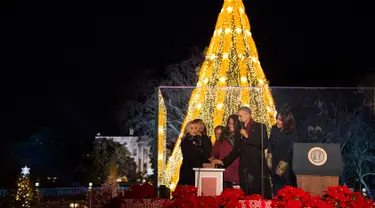 Presiden AS Barack Obama (kedua kanan) didampingi Michele Obama, dan dua putrinya menyalakan Pohon Natal Nasional di Taman Ellipse, dekat Gedung Putih, Washington, Kamis (3/12). Acara tersebut menandai dimulainya musim Natal. (AFP PHOTO/JIM WATSON)