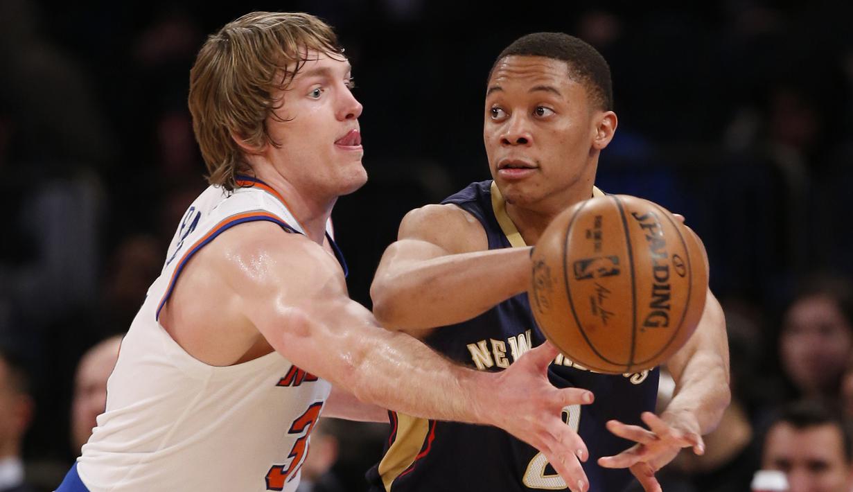 Pemain Pelicans, Tim Frazier (kanan) mengumpan bola melewati hadangan pemain New York Knicks, Ron Baker (kiri) pada laga NBA basketball game di Madison Square Garden, New York (9/1/2017). Pelicans menang 110-96.  (AP/Kathy Willens)