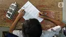 Murid SDN Kota Baru mengikuti ujian penilaian akhir sekolah di SDN Kota Baru 3 Bekasi, Jawa Barat, Senin (8/6/2021). Ujian yang dilaksanakan secara tatap muka tersebut diikuti kelas 4 dan 5. (Liputan6.com/Herman Zakharia)