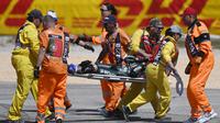 Pebalap CryptoData Aprilia, Miguel Oliveira ditandu petugas trek setelah mengalami tabrakan dengan pebalap Repsol Honda, Marc Marquez pada balapan MotoGP Portugal 2023 di Sirkuit Internasional Algarve, Portimao, Portugal, Minggu (26/3/2023). (AFP/Patricia De Melo Moreira)