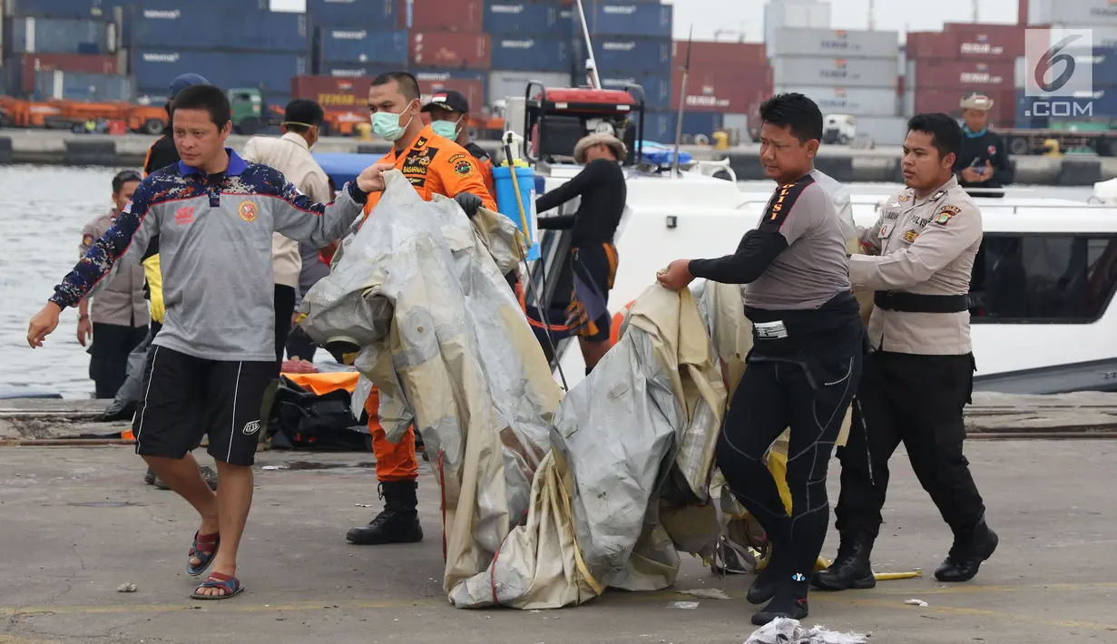 Petugas mengangkat barang property pesawat Lion Air PK-LQP JT 610 di Pelabuhan JICT 2, Jakarta, Senin (5/11). Sejumlah barang ditemukan petugas gabungan dalam operasi pencarian. (Liputan6.com/Helmi Fithriansyah)