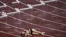 Sara Petersen, dari Denmark, terbaring di lintasan setelah terjatuh saat pertandingan semifinal lari gawang 400 meter putri pada Olimpiade Tokyo 2020,  Senin (2/8/2021). (Foto: AP/Francisco Seco)