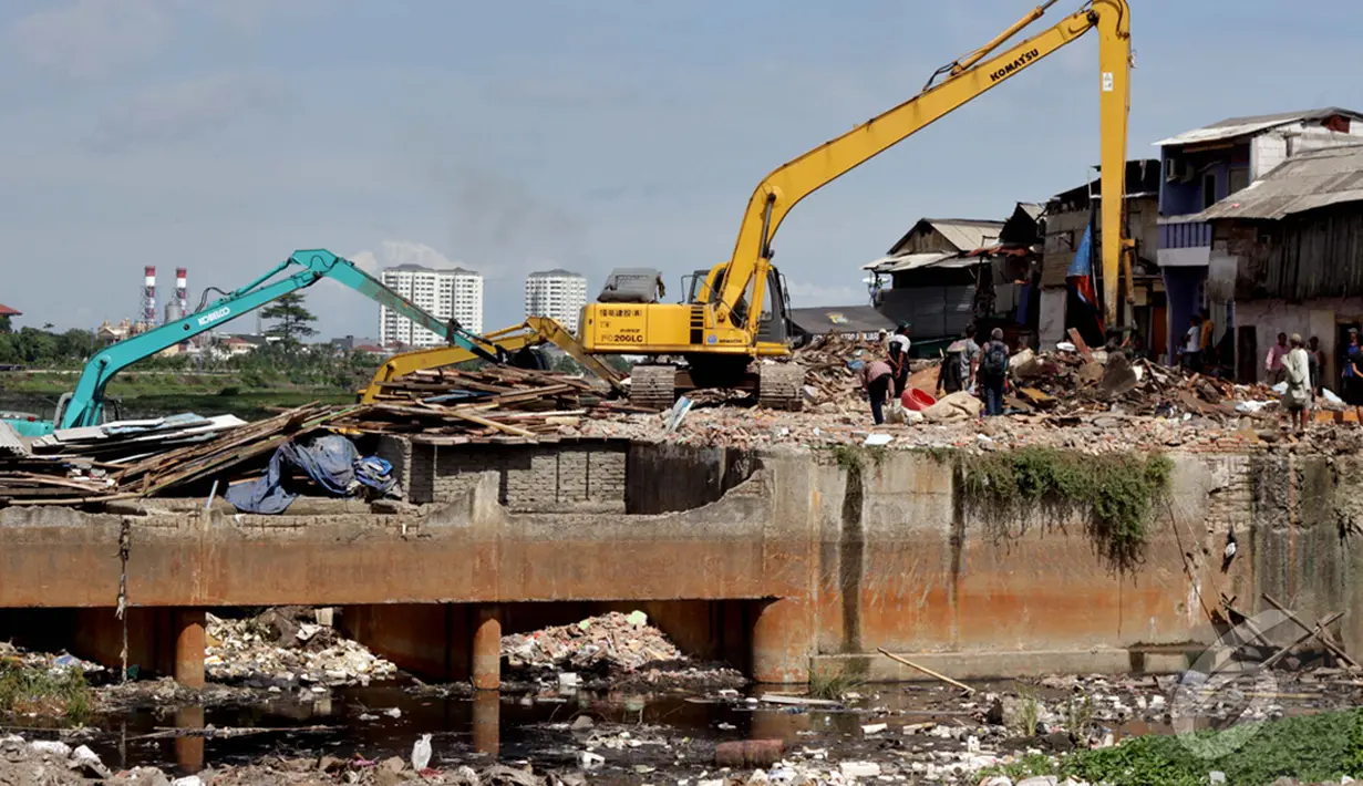 Sebuah alat berat digunakan untuk menghancurkan rumah warga saat penggusuran pemukiman di pinggir Waduk Pluit, Jakarta, Minggu (11/1/2015). (Liputan6.com/Faizal Fanani)