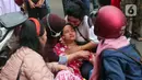 Warga mencoba menenangkan korban kebakaran di kawasan padat penduduk di Jalan Simprug Golf II RT 4/8, Grogol Selatan, Kebayoran Lama, Jakarta Selatan, Minggu (21/8/2022). Hingga siang ini, petugas pemadam kebakaran bersama warga masih terus berusaha untuk memadamkan api. (Liputan6.com/Angga Yuniar)
