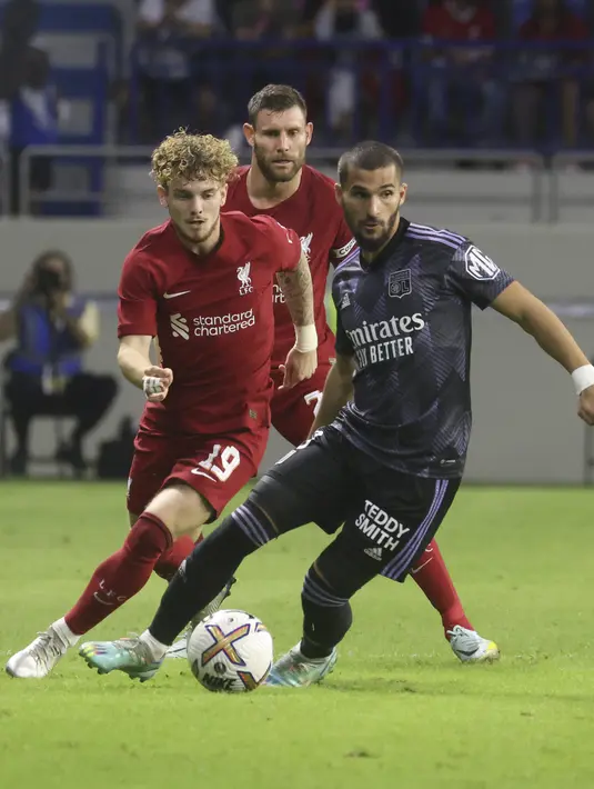 Gelandang Lyon, Houssem Aouar (kanan) membawa bola dari kawalan gelandang Liverpool, Harvey Elliott selama pertandingan Dubai Super Cup 2022 di Al Maktoum Stadium, Uni Emirat Arab, Minggu (11/12/2022). Lyon menang atas Liverpool 3-1. (AFP/Karim Sahib)