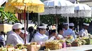 Umat Hindu meletakkan sesajinya di atas meja untuk merayakan Hari Raya Galungan di sebuah pura, Denpasar, Bali, Rabu 17 Juni 2026. (SONNY TUMBELAKA/AFP)