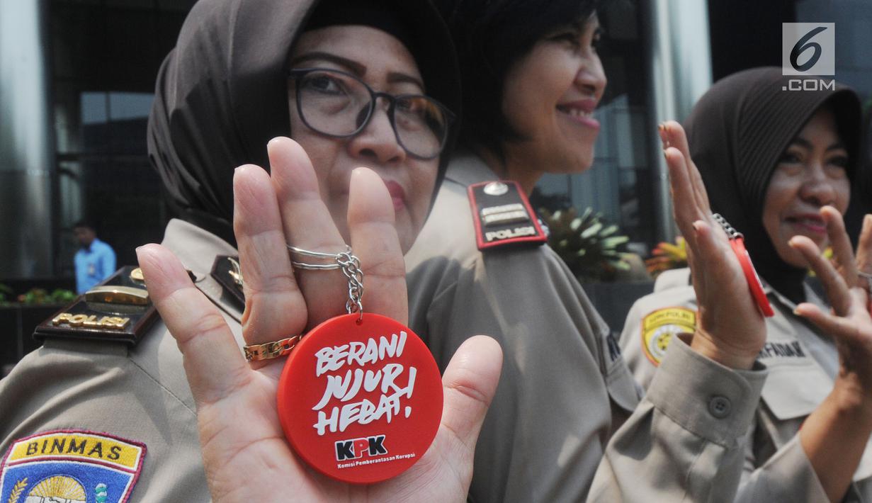 Polisi wanita (polwan) menunjukkan pin antikorupsi di depan Gedung KPK, Jakarta, Kamis (29/8/2019). Jelang HUT ke-71 Polwan RI, sejumlah polisi wanita menggelar pertemuan dengan Wakil Ketua KPK Irjen Pol (Purn) Basaria Panjaitan. (Merdeka.com/Dwi Narwoko)