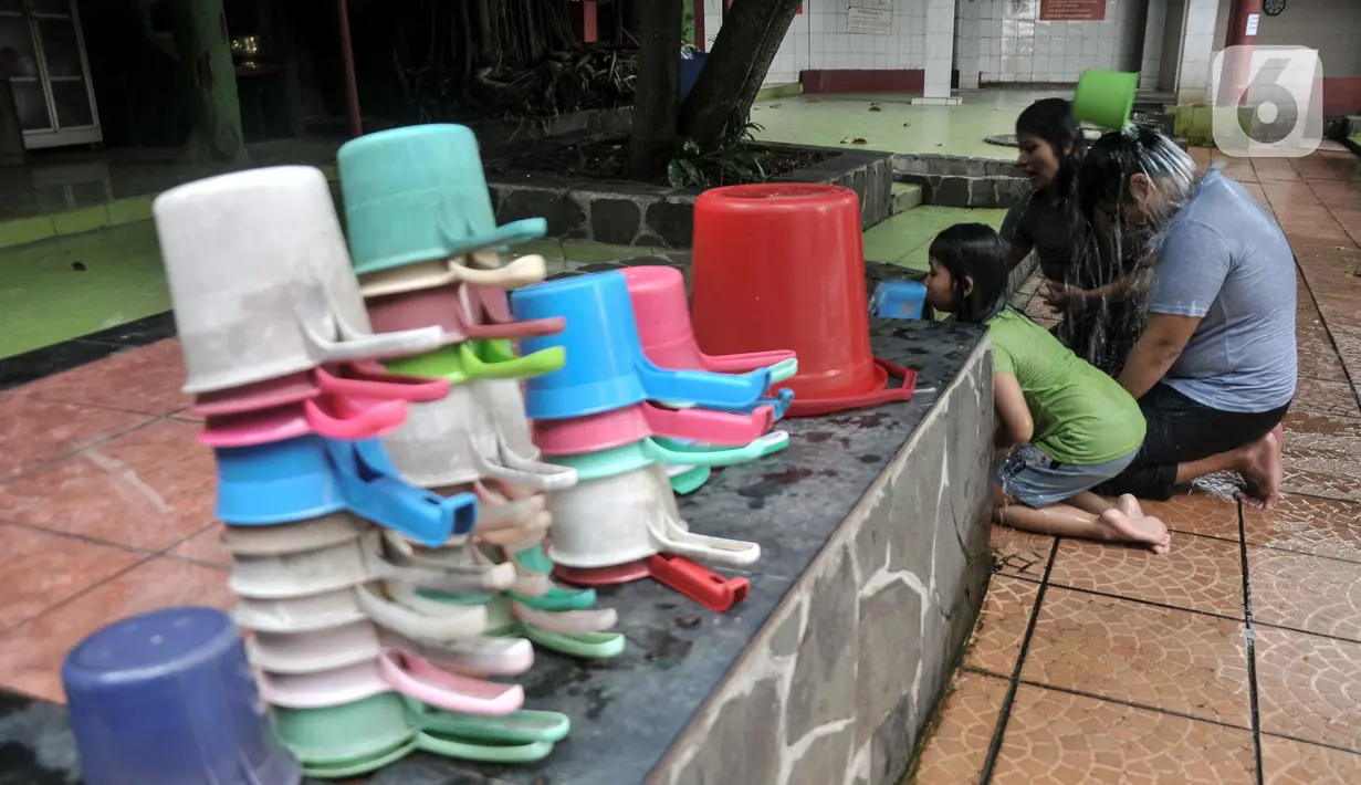 Warga keturunan Tionghoa membersihkan diri di salah satu sumur Vihara Gayatri, Depok, Jawa Barat, Minggu (15/1/2023). (merdeka.com/Iqbal S. Nugroho)