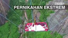 Pasangan di Tiongkok ini, berani menikah di atas tempat tidur menggantung di ketinggian 179 meter. Pengantian pria sempat ketakutan sebelum turun ke tempat tidur. 