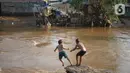 Anak-anak berenang di bantaran Sungai Ciliwung, Jakarta, Senin (5/10/2020). Derasnya aliran Sungai Ciliwung akibat hujan deras yang mengguyur Jakarta tidak menyurutkan kemauan anak-anak tersebut untuk tetap berenang, meski dapat membahayakan keselamatan mereka. (Liputan6.com/Immanuel Antonius)